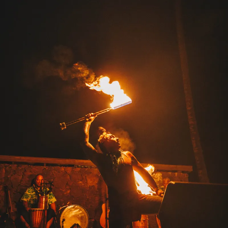 a person in a dark room with smoke and fire