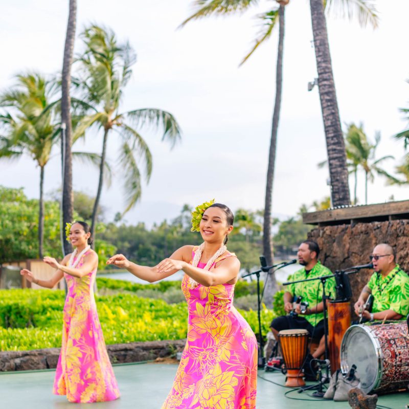 a group of people standing next to a palm tree
